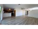 Open-concept living room with light walls, modern ceiling fan, and wood-look floors at 272 S 228Th Ln, Buckeye, AZ 85326
