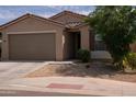 Inviting single-level home featuring a spacious two-car garage, tidy front yard with desert plants, and a classic tile roof at 2723 W Apollo Rd, Phoenix, AZ 85041