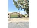 Single-story home with a two-car garage, front yard, and mature shade tree at 2937 E Garnet Cir, Mesa, AZ 85204