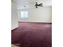 Spacious living room with a ceiling fan, natural light, and neutral-toned walls at 2937 E Garnet Cir, Mesa, AZ 85204
