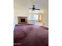 Living room featuring a traditional brick fireplace, ceiling fan, and adjacent dining area at 2937 E Garnet Cir, Mesa, AZ 85204