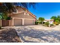 Charming tan home with a three-car garage, long driveway, and professionally landscaped front yard at 3581 W Ironwood Dr, Chandler, AZ 85226