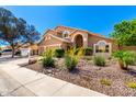 Charming tan home with a three-car garage and professionally landscaped front yard at 3581 W Ironwood Dr, Chandler, AZ 85226