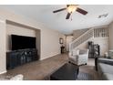Open-concept living room featuring tile floors, neutral paint, a ceiling fan, and a staircase leading to the upper level at 4366 E Lexington Ave, Gilbert, AZ 85234