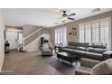 Bright living room with tile floors, plantation shutters, a ceiling fan, and neutral-toned furnishings, bathed in natural light at 4366 E Lexington Ave, Gilbert, AZ 85234