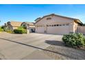 Charming single-story home featuring a well-manicured lawn, desert landscaping, and a spacious three-car garage at 4493 E Desert Sands Dr, Chandler, AZ 85249