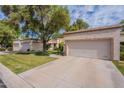Lovely home with a spacious driveway, well-maintained lawn, mature trees, and inviting curb appeal at 9128 W Kimberly Way, Peoria, AZ 85382