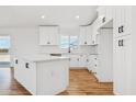 A sleek kitchen featuring white cabinets, a center island, and modern fixtures at 9280 W Wenden Dr, Arizona City, AZ 85123