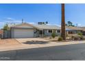 Single-story home with attached garage, desert landscaping, and a quaint, welcoming facade at 100 E Geneva Dr, Tempe, AZ 85282