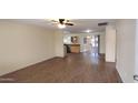 Spacious open-concept living area with modern wood flooring, a ceiling fan, and natural light at 1033 S Florence Dr, Mesa, AZ 85208
