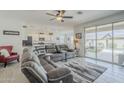 Spacious living room with tile floors, a ceiling fan, and access to the backyard at 12048 E Chevelon Trl, Gold Canyon, AZ 85118