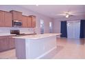 Bright kitchen featuring an island with bar seating, stainless steel appliances and light-colored countertops at 1255 N Arizona Ave # 1216, Chandler, AZ 85225