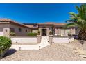 Inviting single-story home showcases lush desert landscaping, a tile roof, and solar panels for energy efficiency at 20394 N Coronado Way, Surprise, AZ 85374