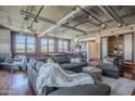 Open-concept living room showcasing a large sectional sofa, exposed brick, a glimpse of the kitchen, and a bedroom at 21 E 6Th St # 316, Tempe, AZ 85281