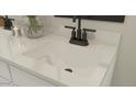Close-up of a bathroom vanity showcasing a sleek undermount sink, modern faucet, and stylish countertop at 23404 W Burton Ave, Buckeye, AZ 85326