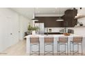 Modern kitchen featuring a large island with barstool seating, stainless steel appliances, and sleek cabinetry at 23404 W Burton Ave, Buckeye, AZ 85326