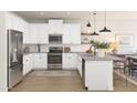 Well-lit kitchen features white cabinets, stainless steel appliances, and a functional island at 23404 W Burton Ave, Buckeye, AZ 85326