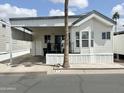 Well-maintained mobile home with covered parking and a welcoming front porch and tidy landscaping at 272 S Cinnabar Dr, Apache Junction, AZ 85119