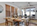 Bright dining room with wood table, decorative center piece, modern chairs, and light-filtering window shades at 29798 N 121St Dr, Peoria, AZ 85383