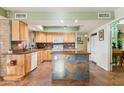 Well-lit kitchen with wooden cabinets, a center island, and sleek countertops at 3146 W Paradise Dr, Phoenix, AZ 85029