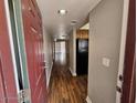 View of entryway that gives open concept access to living area with wooden floor, and kitchen on the right at 3420 W Danbury Dr # C218, Phoenix, AZ 85053