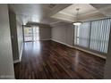 Bright living room with tray ceiling, hardwood floors, and sliding door access to the outside at 3420 W Danbury Dr # C218, Phoenix, AZ 85053