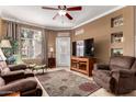 Cozy living room featuring tile floors, a ceiling fan, and large window for ample natural light at 3830 E Lakewood Pkwy # 1057, Phoenix, AZ 85048