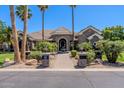 Beautiful single-story stone home with lush landscaping, a fountain, and a brick walkway at 3949 E Norcroft Cir, Mesa, AZ 85215