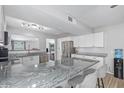 Spacious kitchen with granite countertops, stainless steel appliances, island with seating, and light wood floors at 4815 W Charleston Ave, Glendale, AZ 85308