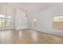 Spacious living room featuring wood-look floors, bright lighting, and vaulted ceilings at 5123 W Novak Way, Laveen, AZ 85339