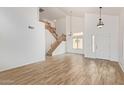 Open-concept living area with a staircase, wood-look floors, and vaulted ceilings at 5123 W Novak Way, Laveen, AZ 85339