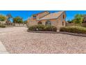 Charming home featuring a balcony, arched window, two-car garage, and desert landscaping at 6101 W Sunnyside Dr, Glendale, AZ 85304