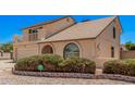 Charming home featuring a balcony, arched window, two-car garage, and desert landscaping at 6101 W Sunnyside Dr, Glendale, AZ 85304