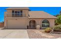 Charming home featuring a balcony, arched window, two-car garage, and low maintenance landscaping at 6101 W Sunnyside Dr, Glendale, AZ 85304