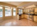 Bright eat-in kitchen featuring stainless steel appliances, tile floors, and ample natural light from the adjacent bay windows at 6101 W Sunnyside Dr, Glendale, AZ 85304