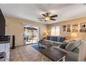 Inviting living room with tile floors, a ceiling fan, and sliding glass doors that lead to the outdoor space at 612 E Racine Pl, Casa Grande, AZ 85122