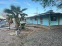 Light-blue exterior featuring a sturdy porch, desert landscaping and mature palm tree at 6447 W Piccadilly Rd, Phoenix, AZ 85033