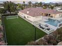 Aerial view of backyard with pool, spa, fire pit, and a sports court for luxurious outdoor recreation at 7129 E Caron Dr, Paradise Valley, AZ 85253