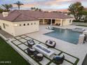 Luxury backyard featuring a pool, spa, fire pit, and lush landscaping, perfect for outdoor entertaining at 7129 E Caron Dr, Paradise Valley, AZ 85253