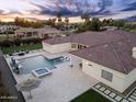 Aerial view of a backyard with a pool, spa, fire pit, and manicured landscaping for luxurious outdoor living at 7129 E Caron Dr, Paradise Valley, AZ 85253