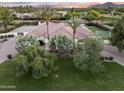 Expansive home exterior surrounded by lush greenery, a well-manicured lawn, and mature trees for a private setting at 7129 E Caron Dr, Paradise Valley, AZ 85253