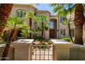 Beautiful home exterior with lush palm trees and arched entry, enhancing its curb appeal and Mediterranean charm at 7475 E Gainey Ranch Rd # 4, Scottsdale, AZ 85258