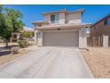 View of a two-story home with desert landscaping, a two-car garage, and a driveway at 9352 W Pioneer St, Tolleson, AZ 85353