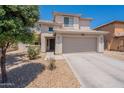 Tan two-story house with a two-car garage, desert landscaping, and tiled roofing at 9352 W Pioneer St, Tolleson, AZ 85353