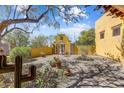 Inviting courtyard with a decorative gate, mature trees, and desert plants at 9415 N 124Th St, Scottsdale, AZ 85259