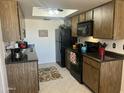 Bright kitchen boasts black appliances, wood cabinetry, a skylight and coordinated decor creating a functional cooking space at 9679 W Cinnabar Ave # B, Peoria, AZ 85345
