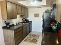 Well-lit kitchen featuring wood cabinets, black appliances, a double basin stainless steel sink, and a skylight above at 9679 W Cinnabar Ave # B, Peoria, AZ 85345