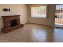 Bright living room showcasing a brick fireplace and a large window for natural light at 9679 W Cinnabar Ave # B, Peoria, AZ 85345