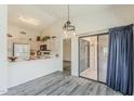 Bright kitchen with vaulted ceilings, breakfast bar, white appliances, and sliding doors to patio at 14300 W Bell Rd # 261, Surprise, AZ 85374