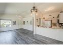 Open floor plan featuring vaulted ceilings, a breakfast bar, modern wood flooring and a ceiling fan at 14300 W Bell Rd # 261, Surprise, AZ 85374